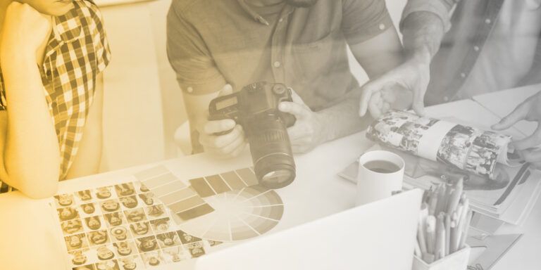 team working on a strategic rebranding strategy looking at photos and color swatches on a table in front of them