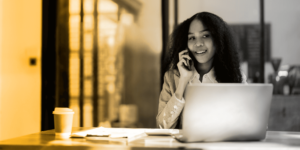 woman on the phone gathering crm contact information while sitting at her computer