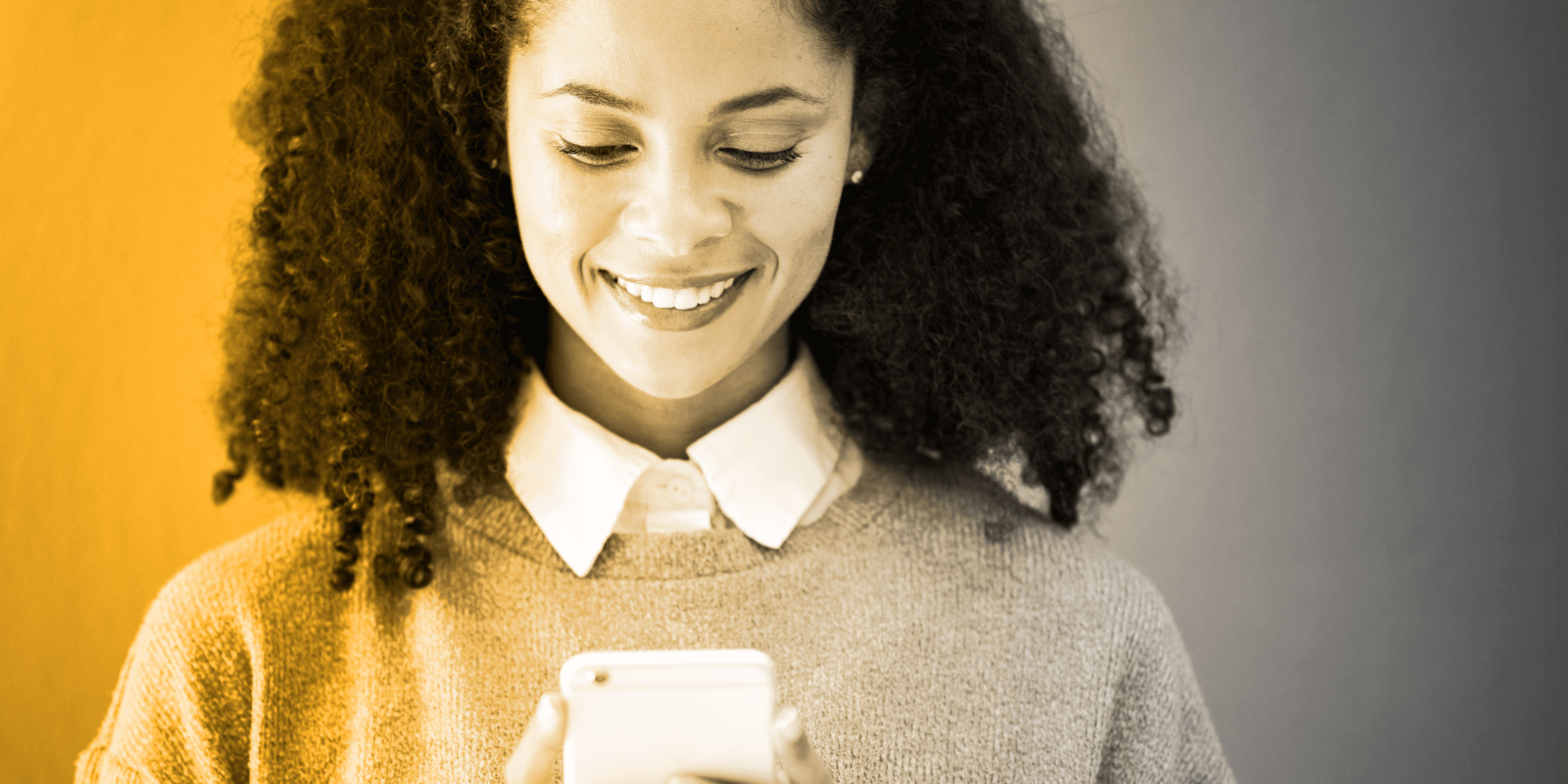 happy woman smiling at her phone after typing in a relevant search term