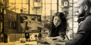 Graphic designers collaborate at a workstation