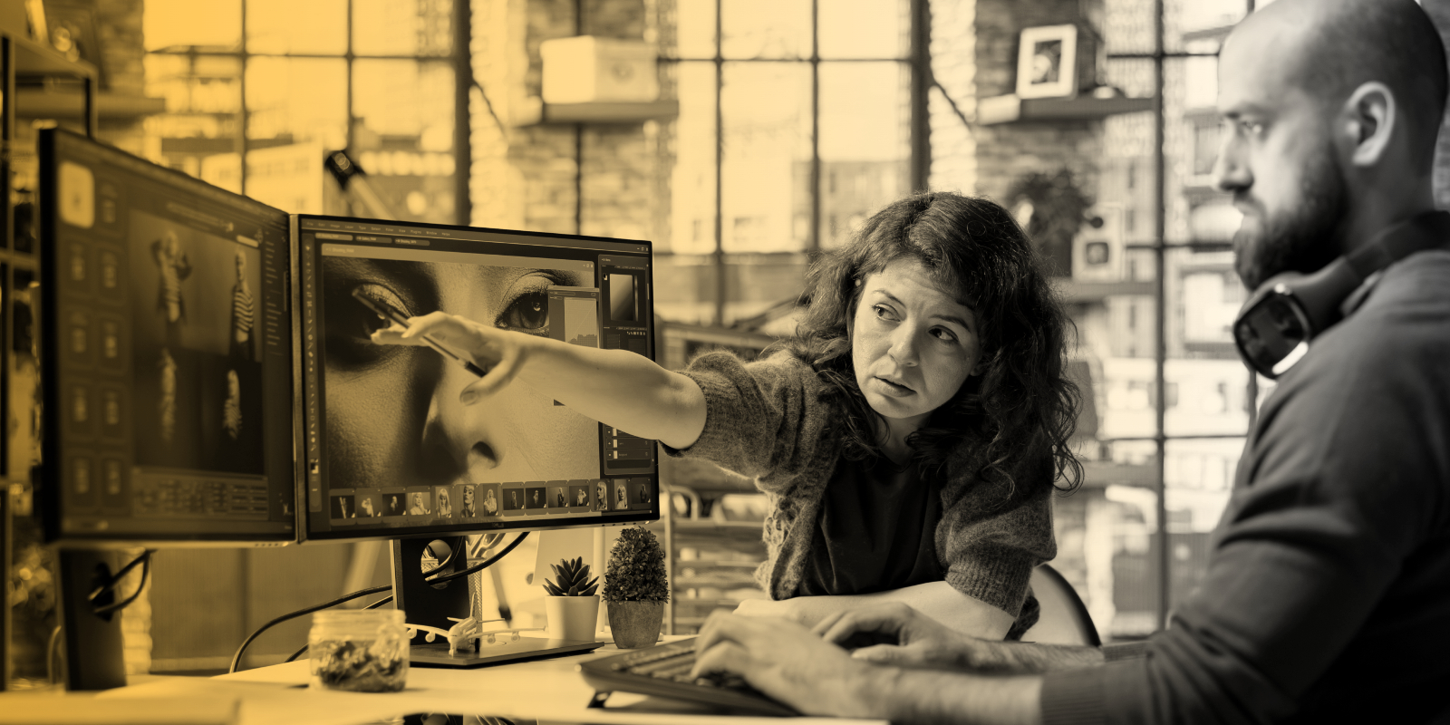 Graphic designers collaborate at a workstation