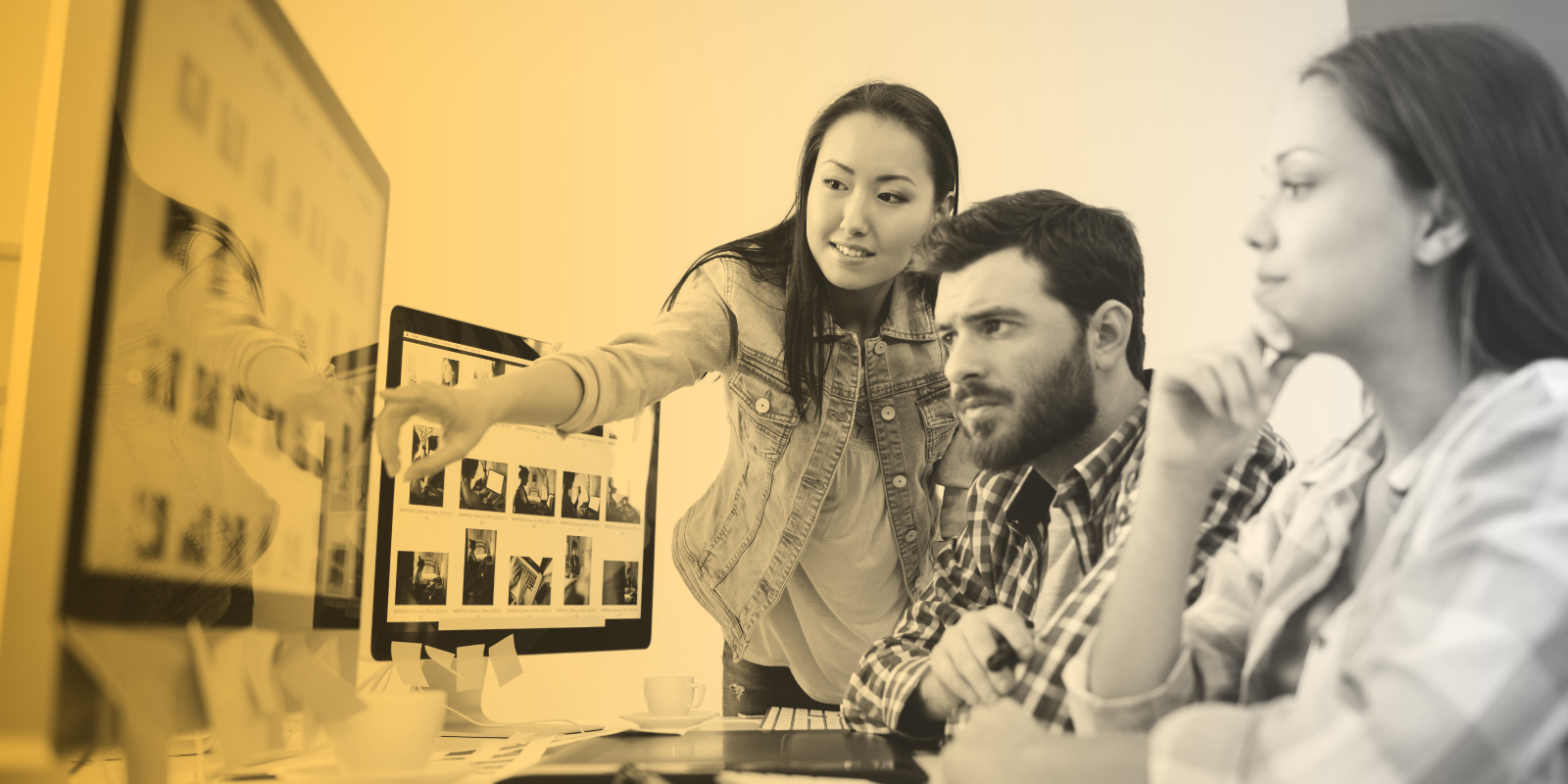 Marketing professionals collaborate at a computer