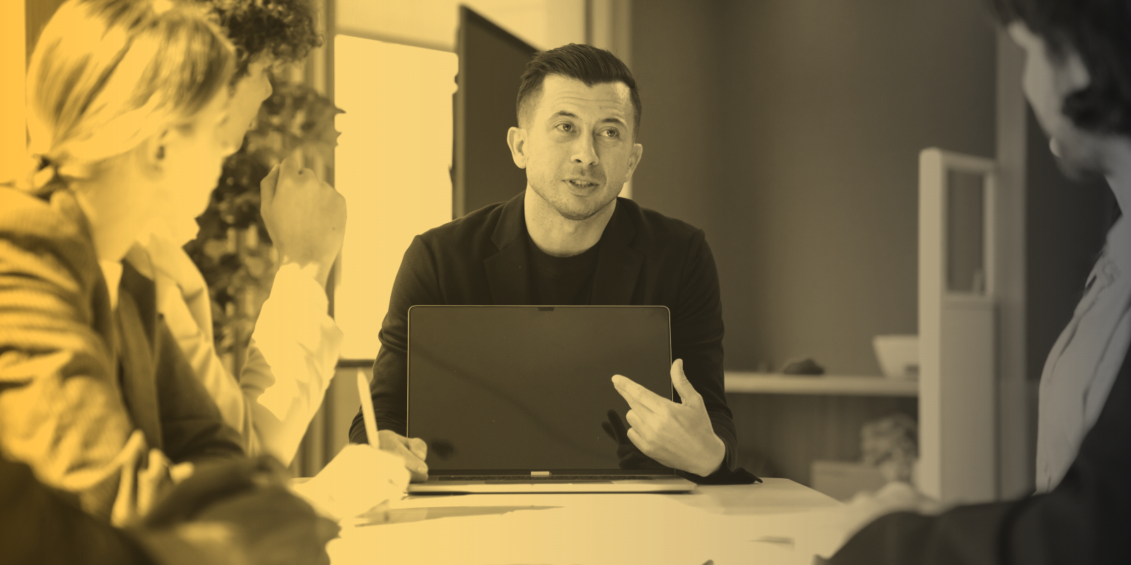 Marketing professionals meet with clients at a long table